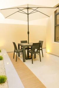a patio with a table and chairs with an umbrella at Sublime Appartement Marrakech in Marrakech