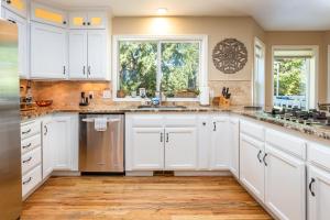 eine Küche mit weißen Schränken und einem großen Fenster in der Unterkunft Sopra Bella- 4 bedroom home in Corvallis