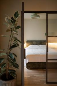 Un dormitorio con una cama y una planta en maceta. en Pievos, en Birštonas