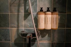 un grupo de tres botellas de champú en una pared en Pievos, en Birštonas 64 fotos más