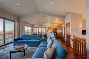a living room with a blue couch and a kitchen at Hill Station in Beech Mountain