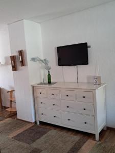 a white dresser with a television on top of it at Fewo Kastel in Nonnweiler
