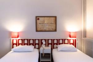 deux lits dans une chambre avec un tableau au mur dans l'établissement Hotel Ours Blanc - Victor Hugo, à Toulouse 62 autres photos