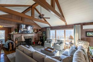 a living room with couches and a tv and a fireplace at Hinesight at Hound Ears in Valle Crucis