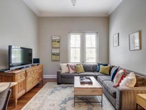 a living room with a couch and a flat screen tv at Charm on Liberty in Savannah