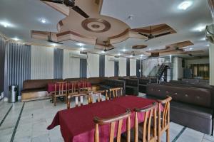 a restaurant with a table and chairs and a couch at Hotel O Mehfil Hotel in Haridwār +38 photos
