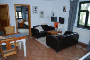 sala de estar con muebles negros y mesa en Fehmarn, en Dargun