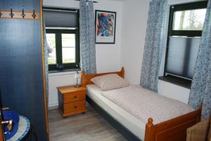 Un dormitorio pequeño con una cama y un espejo. en Fehmarn, en Dargun