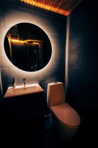 a bathroom with a sink and a toilet and a mirror at Arctic Lumo Resort in Kuusamo