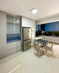 eine Küche mit Tisch und Stühlen und einem Kühlschrank in der Unterkunft Casa de Praia - Brisa do Mar in Aracaju + 49 Fotos