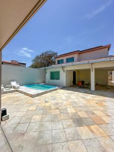 eine Terrasse mit Pool und ein Haus in der Unterkunft Casa de Praia - Brisa do Mar in Aracaju