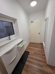 Dieses weiße Zimmer verfügt über ein Waschbecken und ein Fenster. in der Unterkunft Vila Brod in Ljubljana