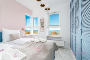 ein Schlafzimmer mit einem Bett und zwei Fenstern in der Unterkunft Your Holidays Aquamarina Onyx 98 in Misdroy