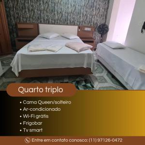 two beds in a room with avertisement for at Hospedaria Monumento in Sao Paulo +16 photos