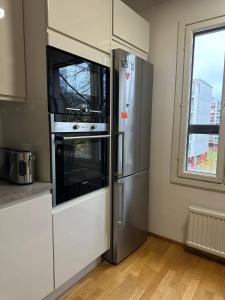 a kitchen with a refrigerator and a microwave at 2 room apartment in Pasila in Helsinki