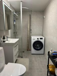 a bathroom with a washing machine and a sink at 2 room apartment in Pasila in Helsinki