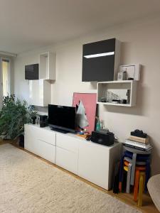 a living room with a white cabinet with a tv on it at 2 room apartment in Pasila in Helsinki +2 photos