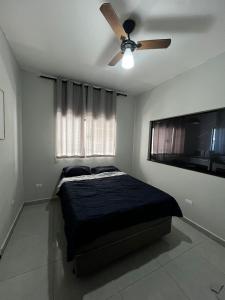 a bedroom with a bed and a ceiling fan at Casa aconchegante in Londrina