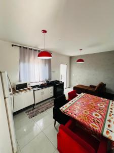 a living room with a table and a kitchen at Casa aconchegante in Londrina