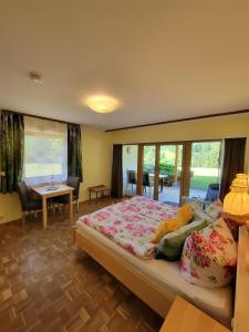 a bedroom with a large bed and a table at Landhaus Fellnerbauer in Bad Reichenhall