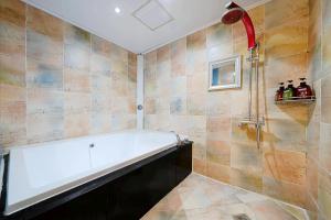 a bathroom with a tub and a shower at v motel in Busan