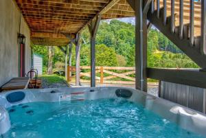 a jacuzzi tub on a porch of a house at The Great Bear Lodge in Vilas