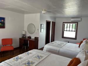 a bedroom with two beds and a desk and a chair at Boots Court Motel in Carthage +10 photos