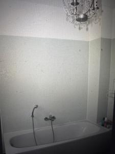 トラフェミュンデにあるKapitänshausのバスルーム(シャンデリア付きのバスタブ付)