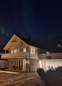 ein großes Haus nachts mit eingeschaltetem Licht in der Unterkunft Central and comfortable apartment in Tromsø in Tromsø
