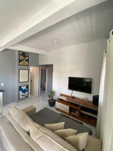 un salon avec un canapé et une télévision à écran plat dans l'établissement Alugo em Porto de Galinhas, à Porto de Galinhas