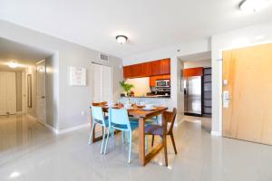 a kitchen and dining room with a wooden table and chairs at Bright & Modern Condo in Brickell w Pool Access in Miami