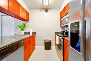 a kitchen with orange cabinets and a sink at Bright & Modern Condo in Brickell w Pool Access in Miami