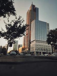 a city street with cars parked in front of tall buildings at BOULEVARD NEST RESlDENCE in Tashkent