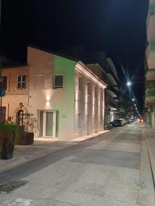una strada vuota di notte con un edificio di Vela Living a Civitanova Marche