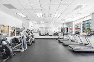 a gym with rows of treadmills and elliptical machines at Bright & Modern Condo in Brickell w Pool Access in Miami +25 photos