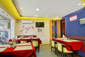 a restaurant with two tables with red table cloth at Hotel O India Gate in Chennai +35 photos