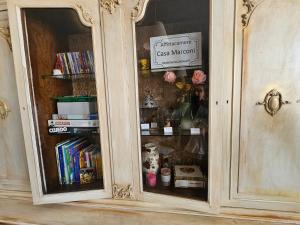a wooden cabinet with a book shelf filled with books at Affittacamere Casa Marconi in Comacchio