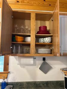 ein Küchenschrank mit Tellern und Geschirr darin in der Unterkunft The coziest Cedar cottage in Fayetteville + 21 Fotos