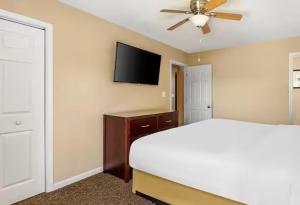 威廉斯堡The Historic Powhatan Resort的一间卧室，里面有一张床和一台平板电视 更多15张照片