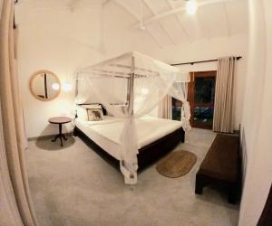 ein Schlafzimmer mit einem großen Bett mit Baldachin in der Unterkunft Serenity Green Unawatuna in Galle + 14 Fotos
