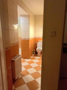 La salle de bains est pourvue de toilettes et de carrelage. dans l'établissement Kwatery prywatne, à Lubartów
