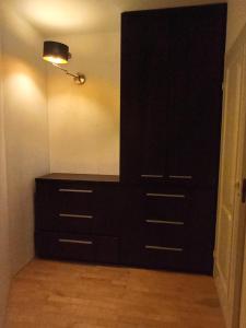 une commode noire dans une pièce avec une lampe dans l'établissement Kwatery prywatne, à Lubartów