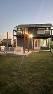 a house with two white benches in a yard at Cabaña sol y luna lugar tranquilo acceso total in Maldonado +9 photos