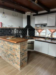 a kitchen with white cabinets and a brick counter top at Cabaña sol y luna lugar tranquilo acceso total in Maldonado