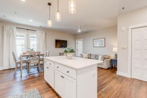 a kitchen and living room with white cabinets and a table at The Pearl Hotel in Manteo