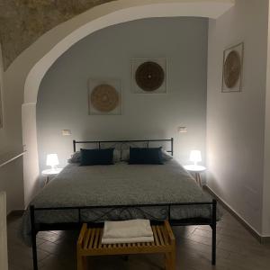 a bedroom with a bed and two tables and two lamps at Petros rooms&apartments in Salerno