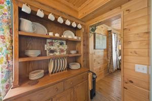 eine Küche mit Holzschränken und Tellern auf Regalen in der Unterkunft Broadstone Cottage in Banner Elk + 50 Fotos