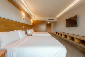 a hotel room with two beds and a flat screen tv at Weston Suites Hotel in Santo Domingo