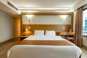 a hotel room with a large bed and a desk at Weston Suites Hotel in Santo Domingo