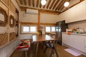 a kitchen and dining room with a table and chairs at Dongmyo Hanok Sihwadang - Private Korean Style House in the City Center with a Beautiful Garden in Seoul